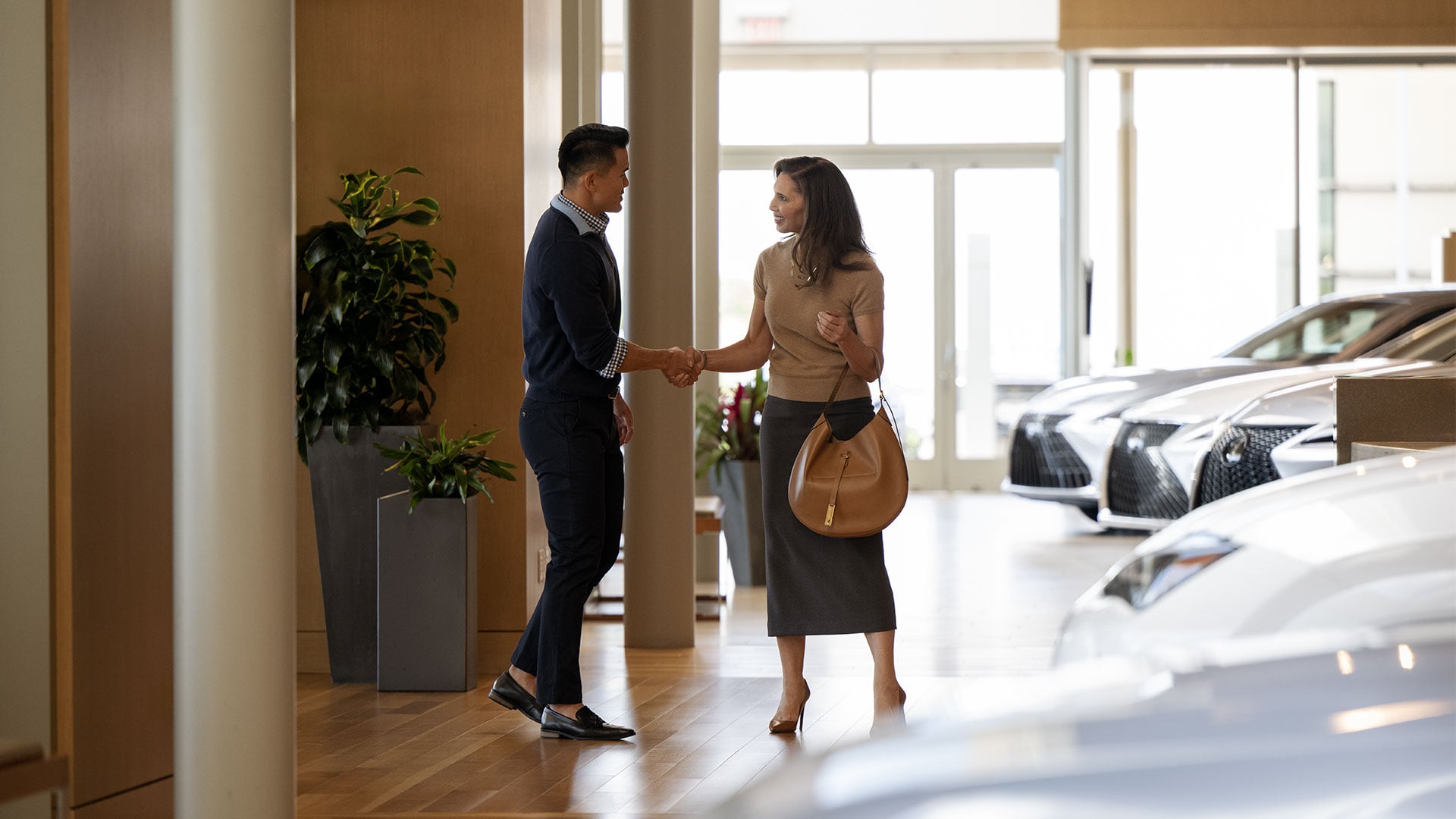 A Lexus Consultant greeting a guest in a dealership