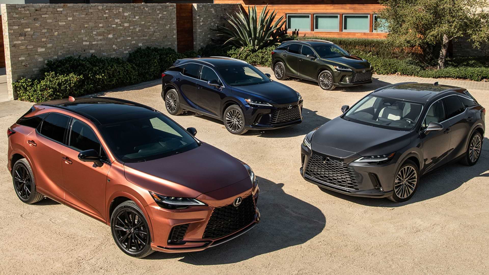 Four Lexus RX SUVs in Copper Crest, Caviar, Nightfall Mica and Nori Green Pearl parked in front of luxury home